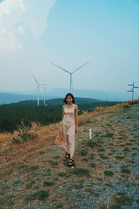 Woman standing on field against sky