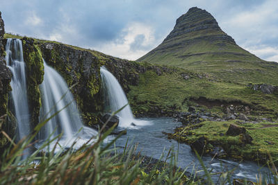 Scenic view of waterfall against sky