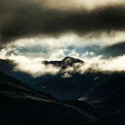 Scenic view of mountains against cloudy sky