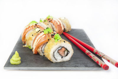 Close-up of sushi on plate against white background