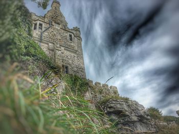 Low angle view of historical building against cloudy sky