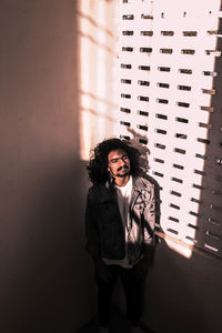 Portrait of young man standing against building wall