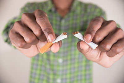 Midsection of man holding cigarettes