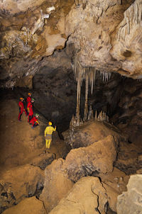 People on rock formation in cave