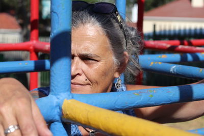 Close-up of woman playing on jungle gym in playground