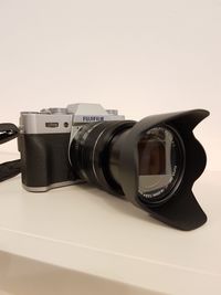 Close-up of camera on table against white background