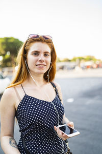 Friendly woman with smartphone listening to music