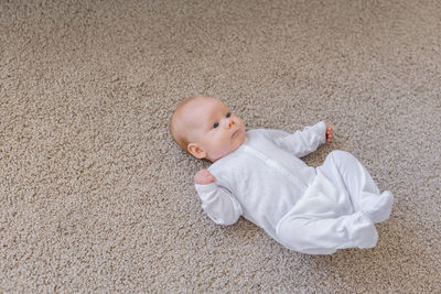 High angle view of baby girl lying on floor