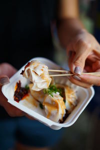 Close-up of hand holding ice cream in plate