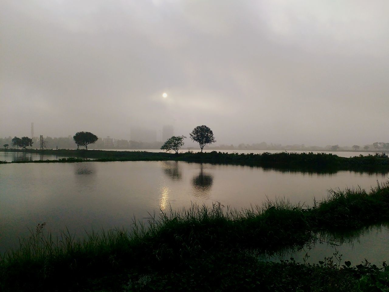 water, tranquil scene, tranquility, sky, scenics, reflection, beauty in nature, lake, nature, grass, tree, idyllic, cloud - sky, plant, growth, calm, non-urban scene, outdoors, dusk, no people