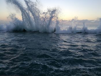 Close-up of waves splashing in sea against sky