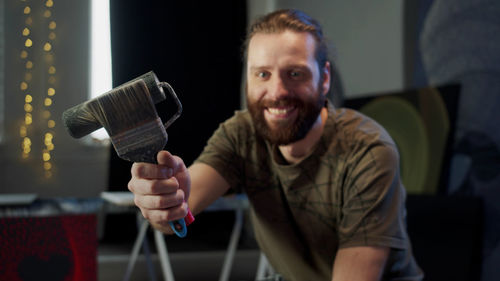 Portrait of young man holding camera