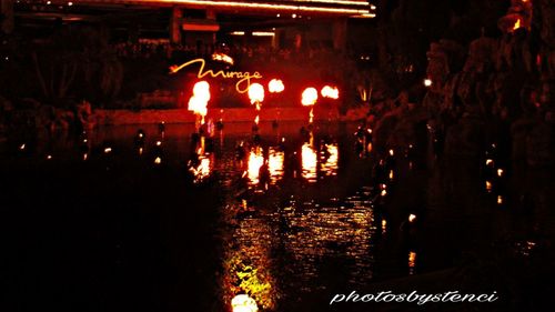 People in illuminated water at night