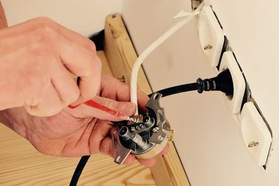 Cropped image of man repairing electrical outlet