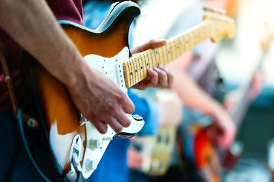 Midsection of man playing guitar