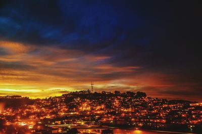 Illuminated cityscape against sky at night