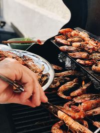 High angle view of person preparing food on barbecue grill