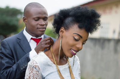 Young man in a suit carrying the chain to his wife outside.