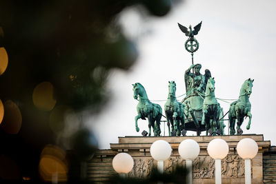 Low angle view of statue against illuminated sculpture