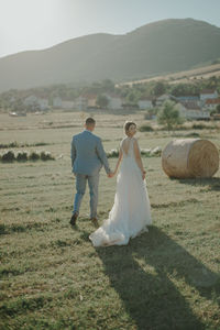 Rear view of couple kissing on landscape