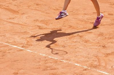 Low section of woman legs on sand