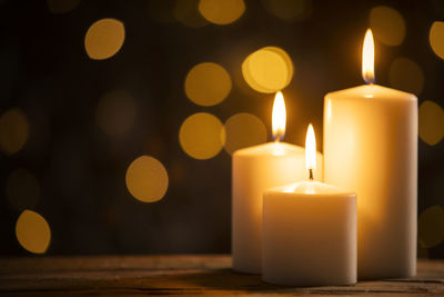 Close-up of illuminated candles on table during christmas