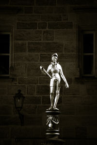 Portrait of man with statue against building