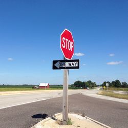 Road sign against blue sky