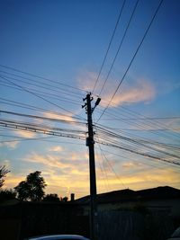 Low angle view of silhouette electricity pylon against sky during sunset