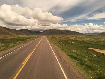 Empty road along countryside landscape