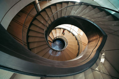 Boy walking on steps of spiral staircase