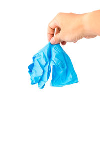 Close-up of hand holding blue plastic against white background
