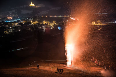 Firework display over illuminated city at night