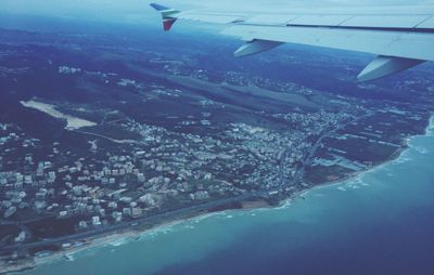 Cropped image of airplane wing over landscape