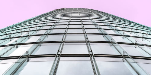 Low angle view of glass building against clear sky