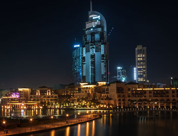 Illuminated buildings against sky at night