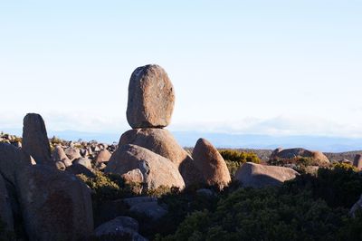 Rear view of man on rock against sky
