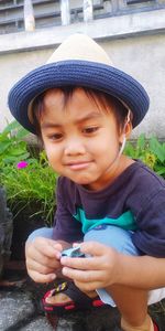 Portrait of cute boy holding hat
