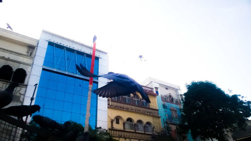 Low angle view of flags in city against sky