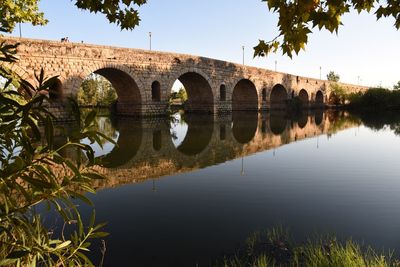 Arch bridge over lake against sky