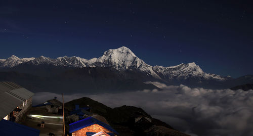 Scenic view of snowcapped mountains against sky at night