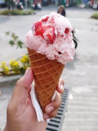 Close-up of hand holding ice cream cone