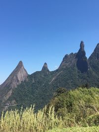 Scenic view of mountains against clear blue sky