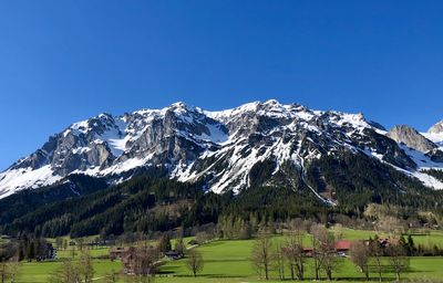 Scenic view of snowcapped mountains against clear blue sky