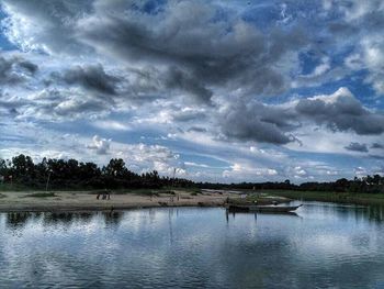 Scenic view of calm lake against cloudy sky