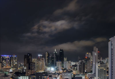 Illuminated buildings in city against sky at night