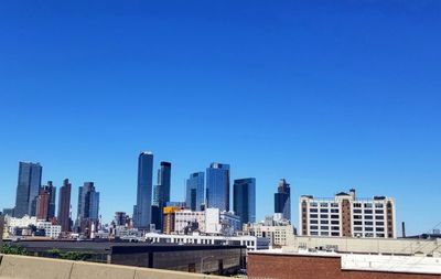 Buildings in city against blue sky