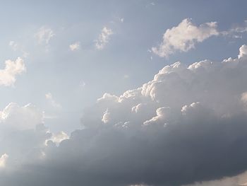 Low angle view of sunlight streaming through clouds