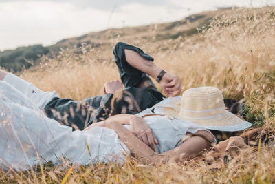 Rear view of couple relaxing on field