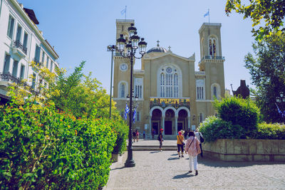 People in front of building against sky